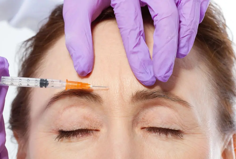 A woman getting an injection in her forehead.